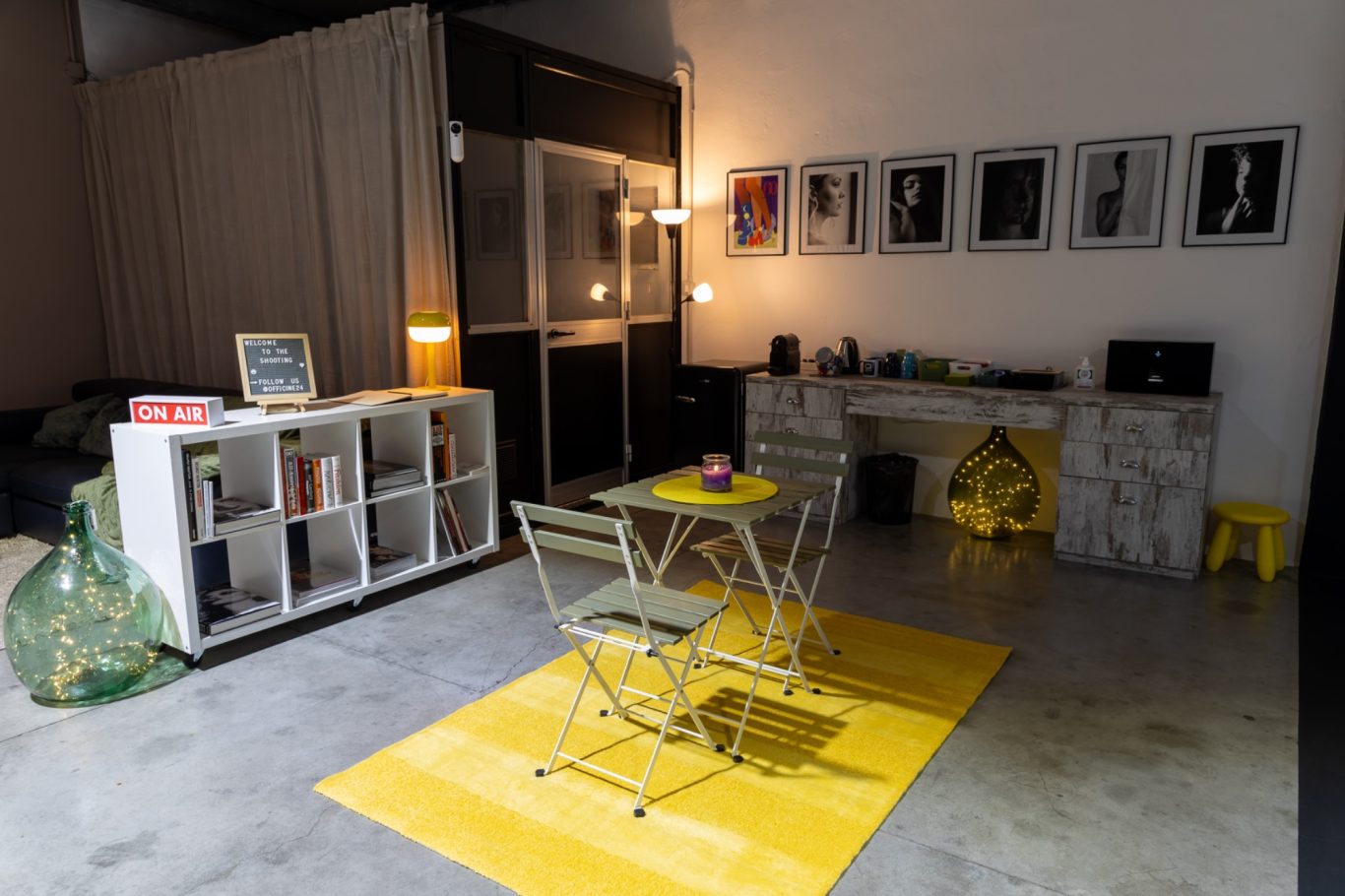 Interni moderni con un tavolino con sedie, tappeto giallo e arte in bianco e nero.