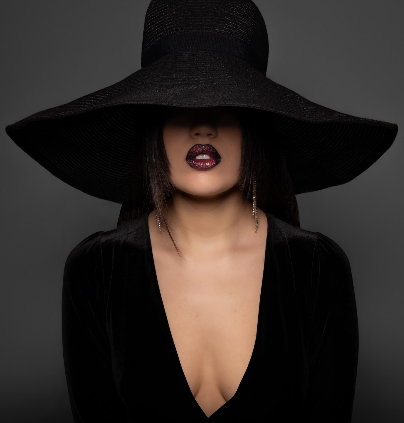 Modella posa con cappello in studio fotografico professionale ad Alessandria