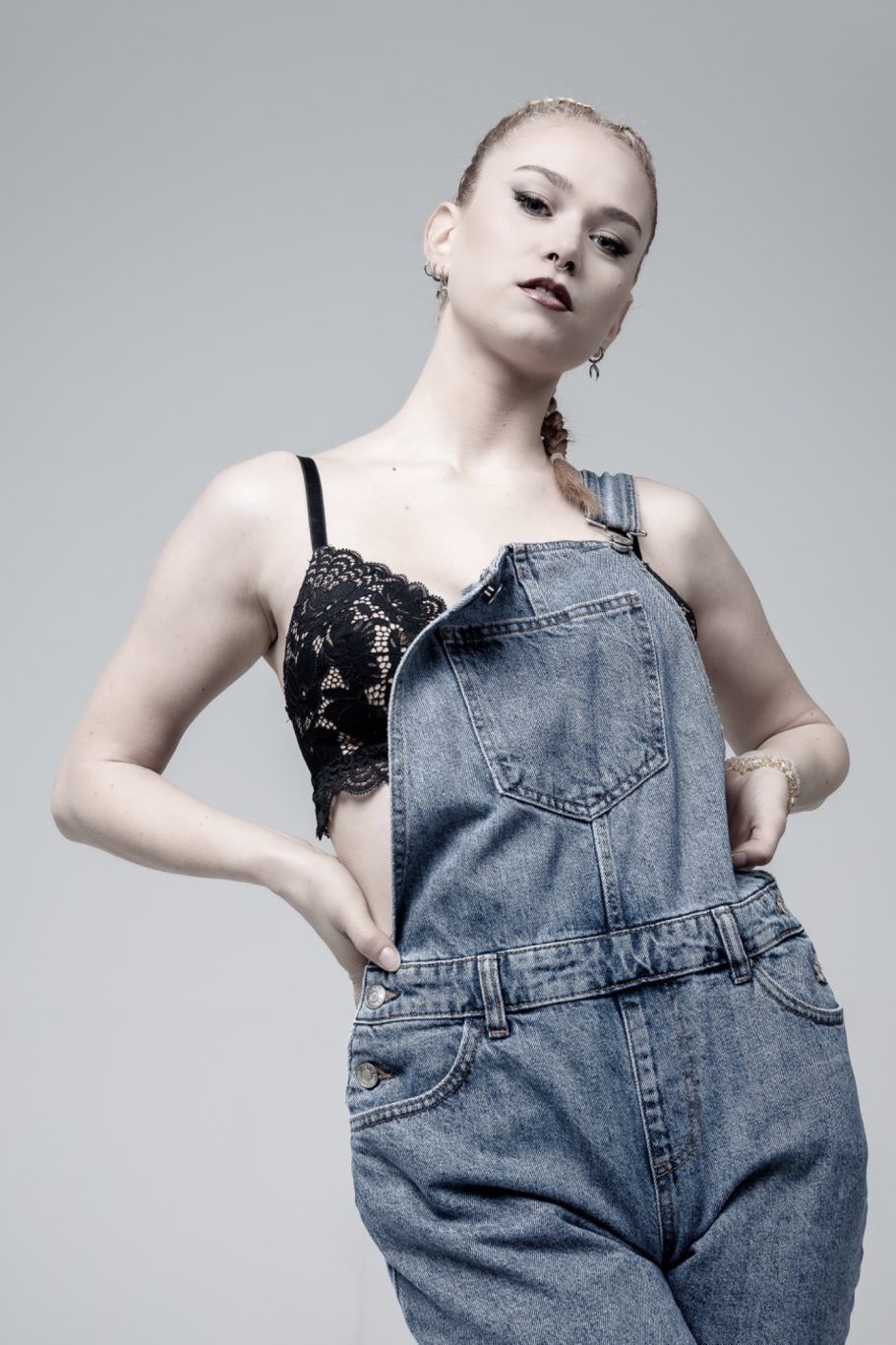 Modella con  un top in pizzo nero con tuta in denim, servizio fotografico