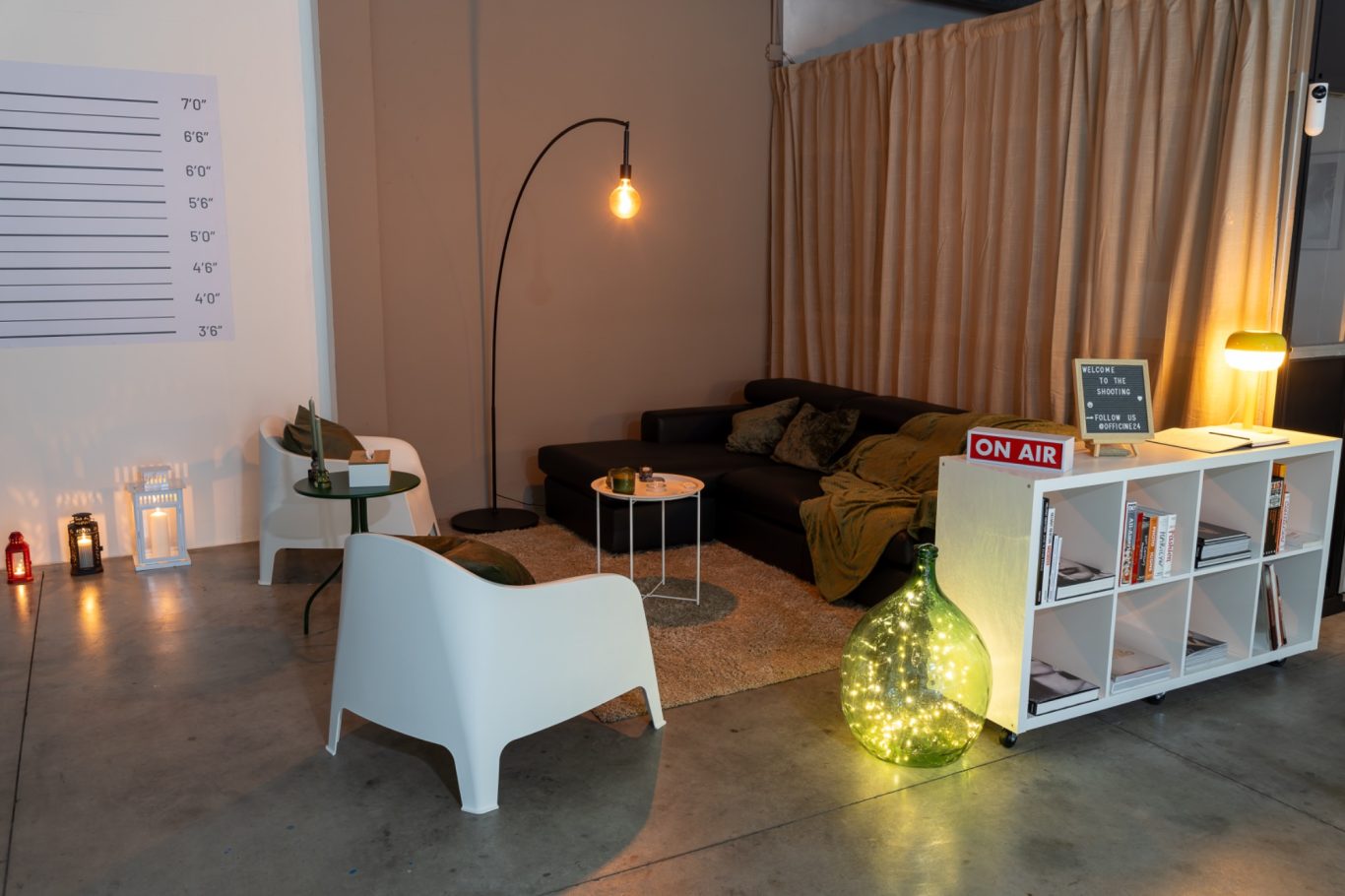 Comodo soggiorno con divano, lampada da terra, libreria ed elementi decorativi.