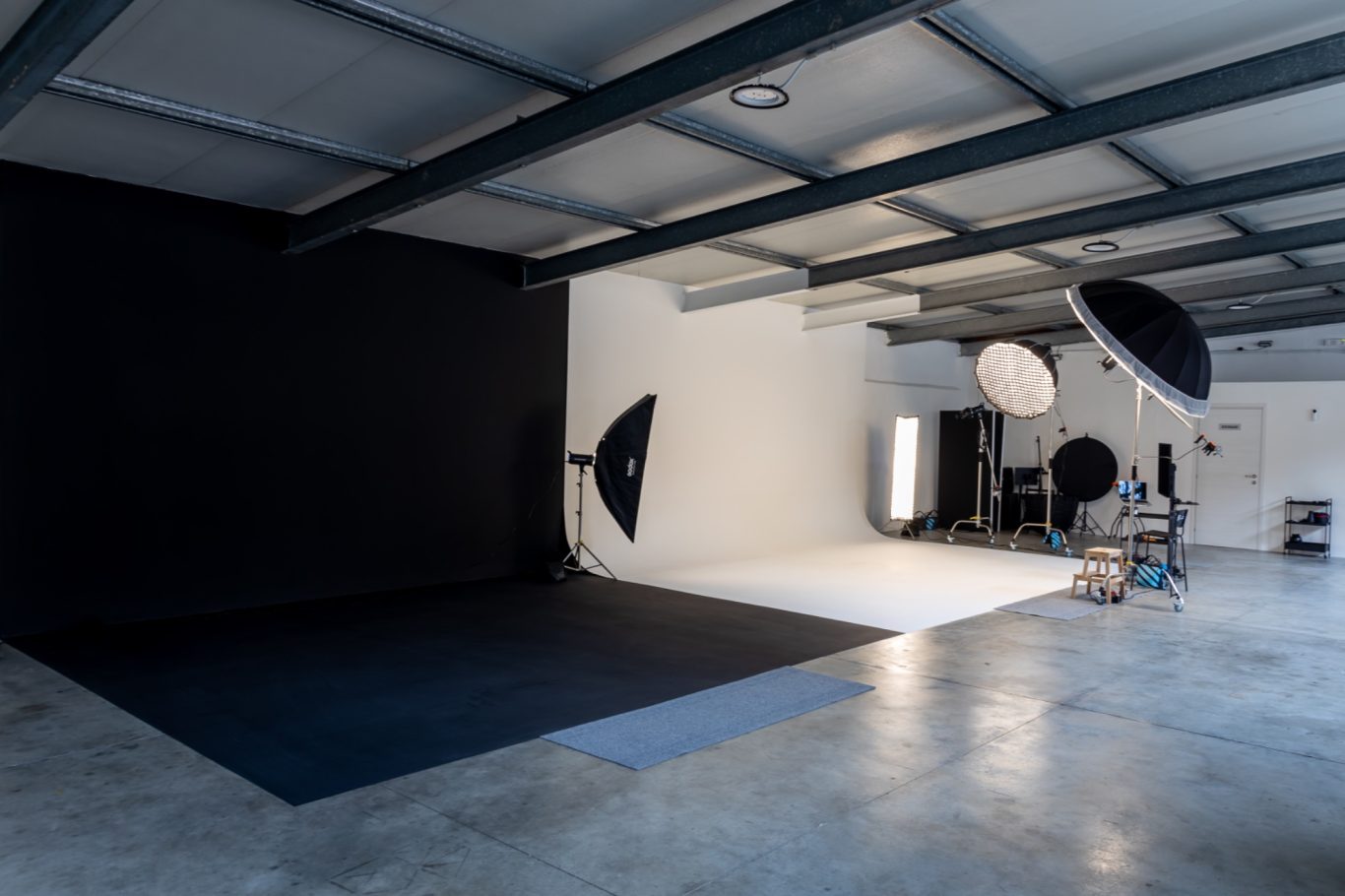 Spazio studio fotografico con sfondi in bianco e nero, illuminazione softbox e flash